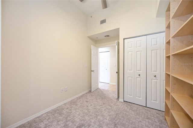 1064 N Tamiami Trl Unit 1125, Sarasota, FL 34236 - unfurnished bedroom with a towering ceiling, light carpet, and a closet