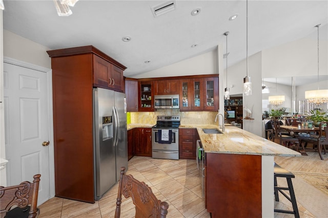 7716 Geneva Ln, Sarasota, FL 34243 - kitchen featuring appliances with stainless steel finishes, a peninsula, lofted ceiling, glass insert cabinets, and tasteful backsplash
