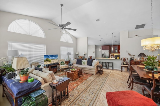 7716 Geneva Ln, Sarasota, FL 34243 - living room featuring healthy amount of natural light, a chandelier, high vaulted ceiling, ceiling fan, and light tile patterned floors