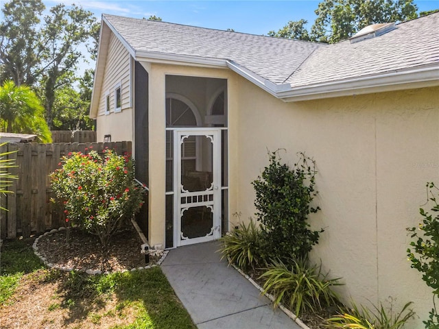 7716 Geneva Ln, Sarasota, FL 34243 - view of exterior entry featuring roof with shingles and stucco siding