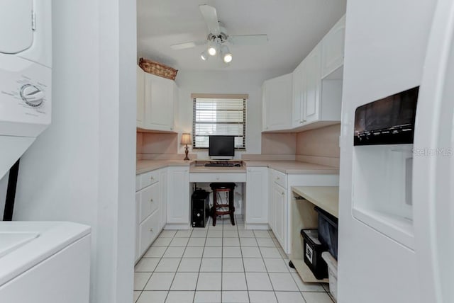 7110 Fairway Bend Ln Unit 181, Sarasota, FL 34243 - kitchen featuring estacked washer and dryer, light tile patterned flooring, white cabinetry, built in study area, and ceiling fan