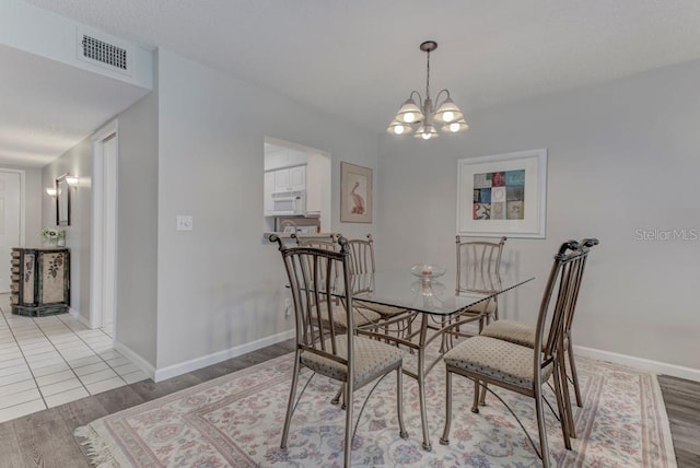 7110 Fairway Bend Ln Unit 181, Sarasota, FL 34243 - dining room featuring light wood-style flooring and a chandelier