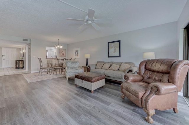 7110 Fairway Bend Ln Unit 181, Sarasota, FL 34243 - living room with a chandelier, light wood-style floors, a ceiling fan, and a textured ceiling
