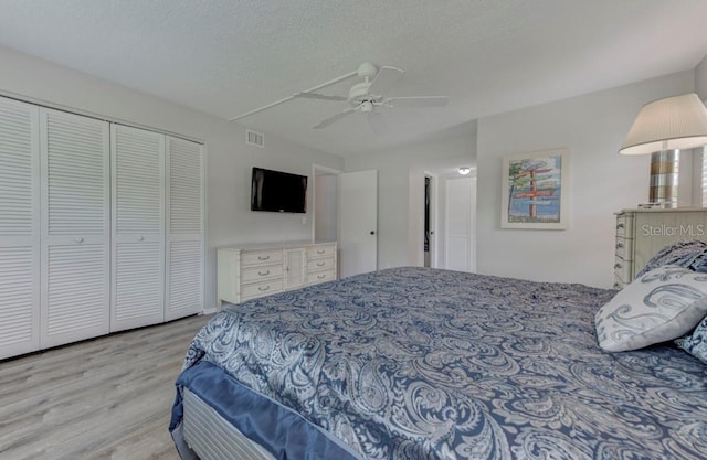 7110 Fairway Bend Ln Unit 181, Sarasota, FL 34243 - bedroom with wood finished floors, a closet, a textured ceiling, and ceiling fan