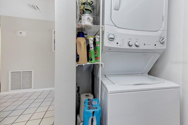 7110 Fairway Bend Ln Unit 181, Sarasota, FL 34243 - washroom with stacked washer and clothes dryer and light tile patterned floors