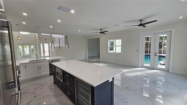 1240 Solitude Ln, Sarasota, FL 34242 - kitchen with light marble finish floors, open floor plan, wine cooler, recessed lighting, and a kitchen island
