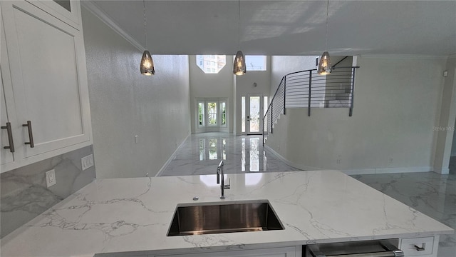 1240 Solitude Ln, Sarasota, FL 34242 - kitchen with marble tiled floors, light stone counters, open floor plan, and crown molding