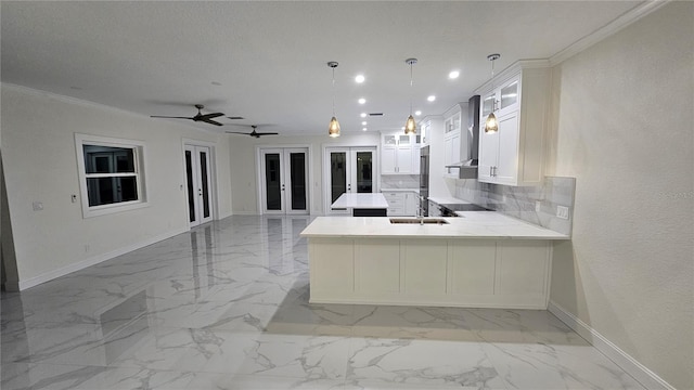 1240 Solitude Ln, Sarasota, FL 34242 - kitchen with wall chimney exhaust hood, french doors, a peninsula, light marble finish floors, and light countertops