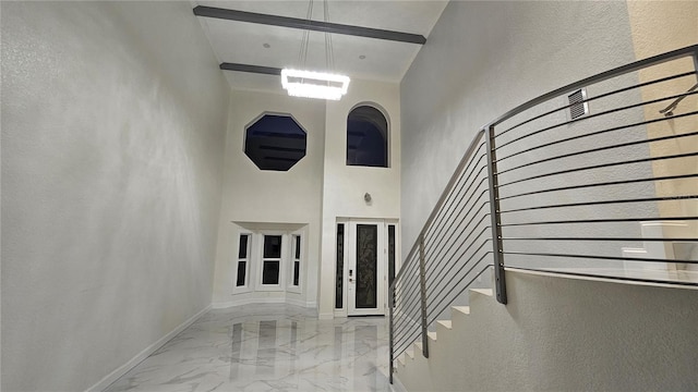 1240 Solitude Ln, Sarasota, FL 34242 - entrance foyer with a high ceiling, marble tiled floors, stairs, a chandelier, and a textured wall