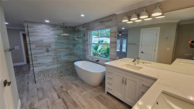 1240 Solitude Ln, Sarasota, FL 34242 - bathroom featuring ornamental molding, vanity, a walk in shower, a freestanding tub, and wood finished floors