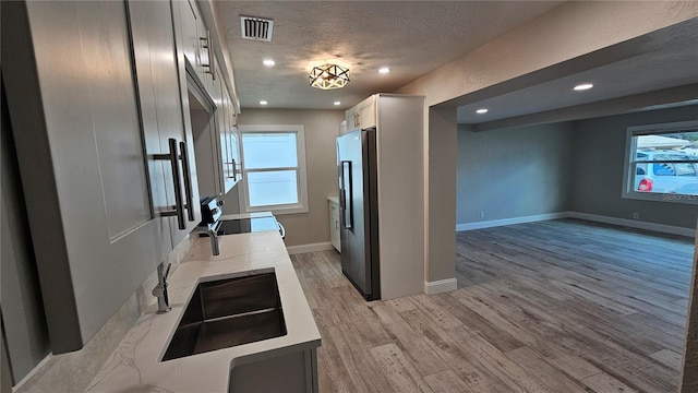 1240 Solitude Ln, Sarasota, FL 34242 - kitchen featuring range with electric stovetop, fridge, recessed lighting, light wood-type flooring, and a textured ceiling