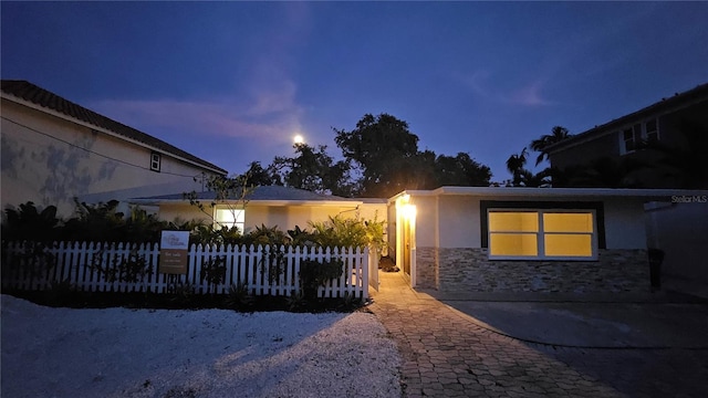1240 Solitude Ln, Sarasota, FL 34242 - ranch-style house with stone siding, a fenced front yard, and stucco siding
