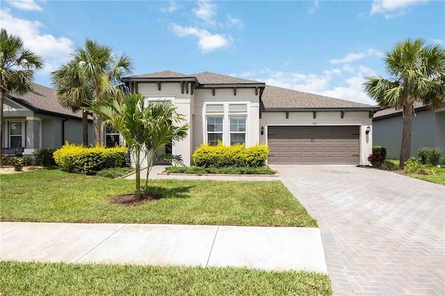 918 Fernleaf Run, Bradenton, FL 34212 - view of front of house featuring an attached garage, decorative driveway, a front yard, and stucco siding
