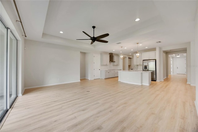 918 Fernleaf Run, Bradenton, FL 34212 - unfurnished living room featuring light wood-style floors, ceiling fan, recessed lighting, and a raised ceiling