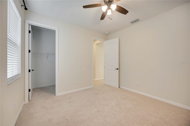 918 Fernleaf Run, Bradenton, FL 34212 - unfurnished bedroom with light colored carpet, a ceiling fan, a closet, and a spacious closet