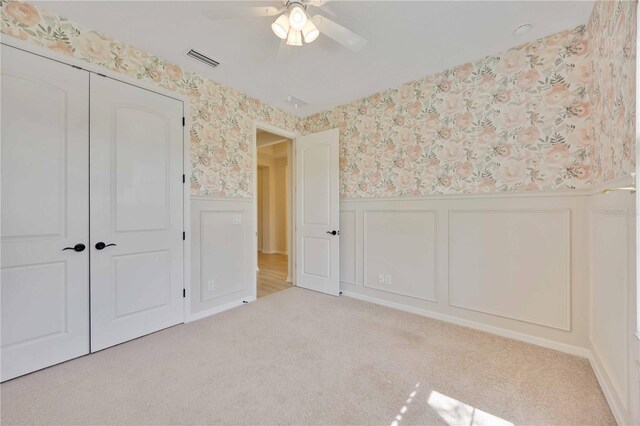 918 Fernleaf Run, Bradenton, FL 34212 - unfurnished bedroom with a wainscoted wall, wallpapered walls, a closet, carpet, and a decorative wall