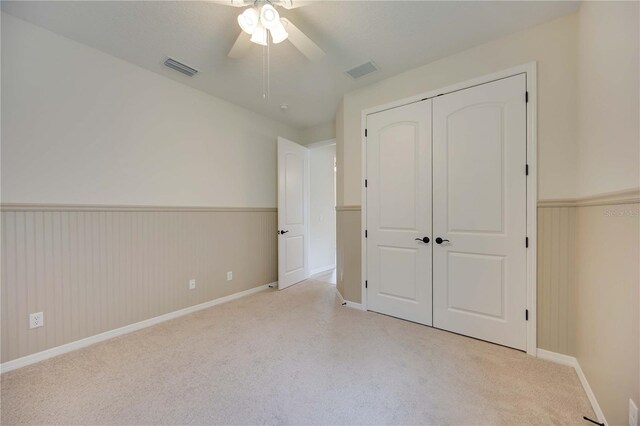 918 Fernleaf Run, Bradenton, FL 34212 - unfurnished bedroom with carpet, a wainscoted wall, a closet, and a ceiling fan