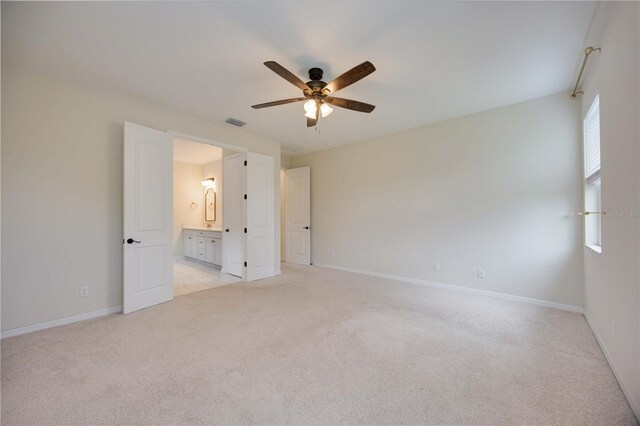 918 Fernleaf Run, Bradenton, FL 34212 - unfurnished bedroom featuring light colored carpet, connected bathroom, and ceiling fan