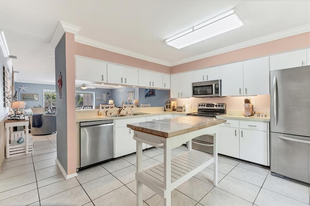 3810 75th St W Unit 128, Bradenton, FL 34209 - kitchen featuring stainless steel appliances, light countertops, crown molding, light tile patterned floors, and white cabinets