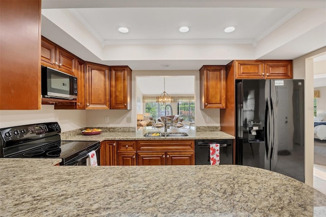 3617 Yellow Pine Ct Unit 144, Sarasota, FL 34238 - kitchen with black appliances, a raised ceiling, ornamental molding, light stone countertops, and brown cabinets