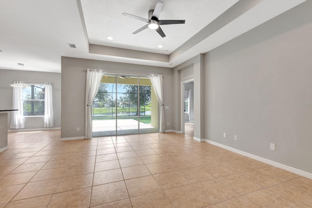 5005 Torrey Pines Run, Bradenton, FL 34211 - unfurnished room featuring a ceiling fan, healthy amount of natural light, light tile patterned floors, and a tray ceiling