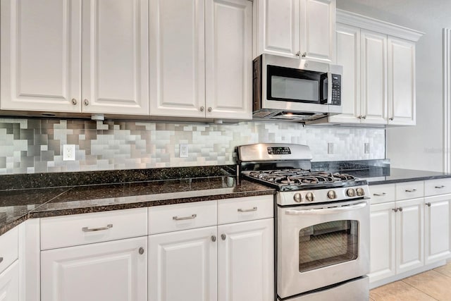 5005 Torrey Pines Run, Bradenton, FL 34211 - kitchen with appliances with stainless steel finishes, white cabinets, backsplash, light tile patterned floors, and dark stone counters