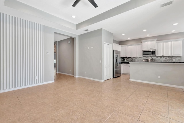 5005 Torrey Pines Run, Bradenton, FL 34211 - kitchen featuring appliances with stainless steel finishes, dark countertops, light tile patterned floors, ceiling fan, and backsplash