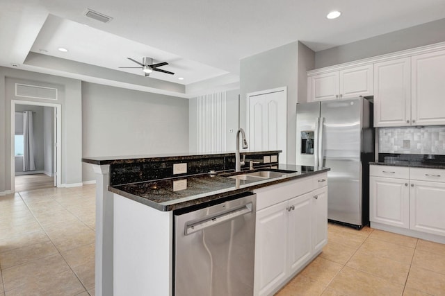 5005 Torrey Pines Run, Bradenton, FL 34211 - kitchen featuring stainless steel appliances, a raised ceiling, light tile patterned flooring, a center island with sink, and white cabinetry