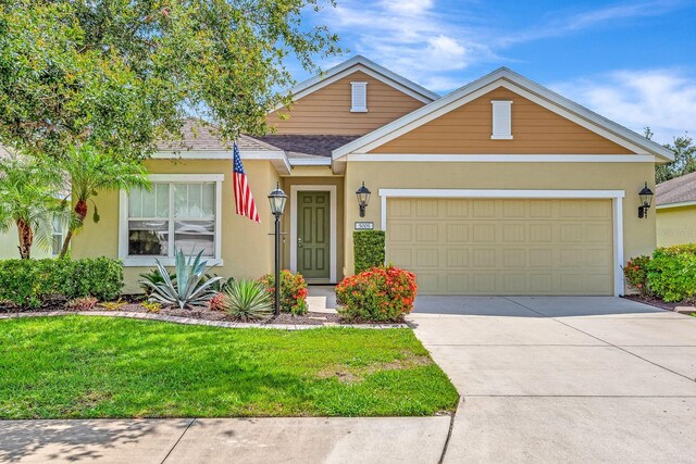 5005 Torrey Pines Run, Bradenton, FL 34211 - view of front of property featuring stucco siding, a front lawn, a garage, concrete driveway, and a shingled roof