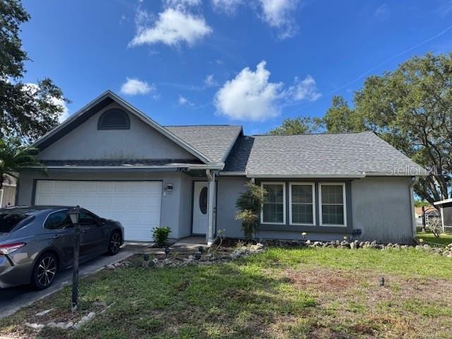 3404 56th Dr E, Bradenton, FL 34203 - single story home with an attached garage, stucco siding, concrete driveway, a front lawn, and roof with shingles