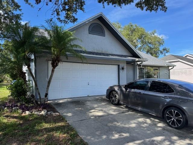 3404 56th Dr E, Bradenton, FL 34203 - view of front of property with stucco siding, a garage, and concrete driveway