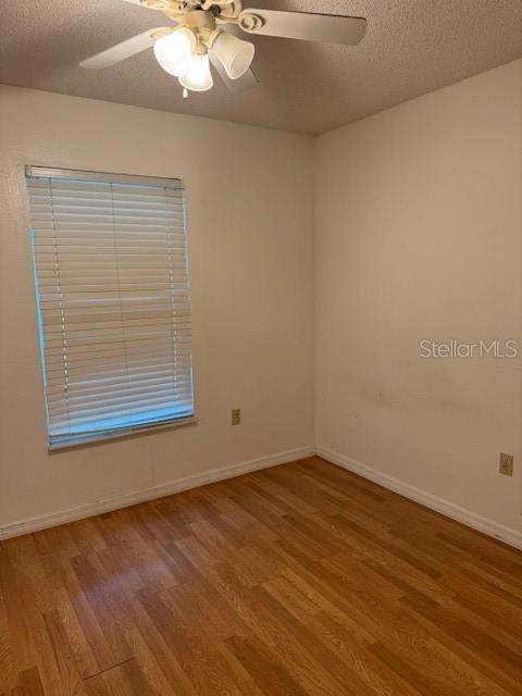3404 56th Dr E, Bradenton, FL 34203 - empty room featuring wood finished floors, a ceiling fan, and a textured ceiling
