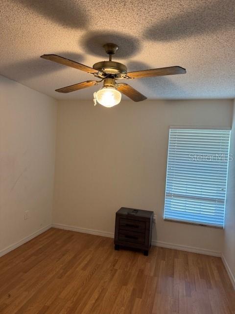 3404 56th Dr E, Bradenton, FL 34203 - empty room with light wood finished floors, a textured ceiling, and ceiling fan