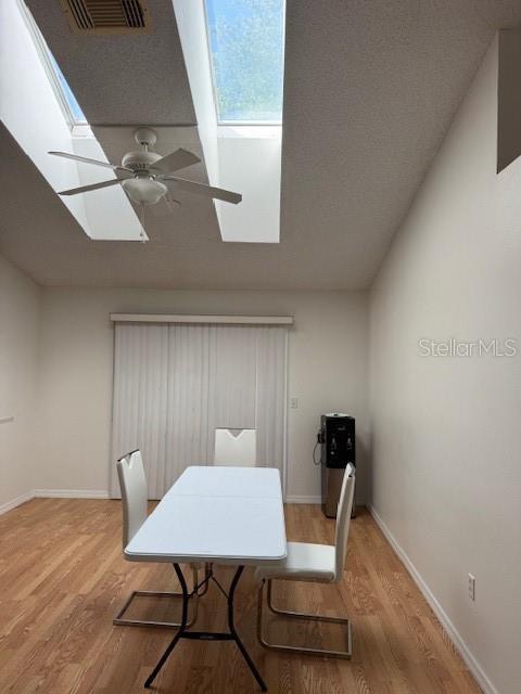 3404 56th Dr E, Bradenton, FL 34203 - dining area with a skylight, wood finished floors, and a ceiling fan