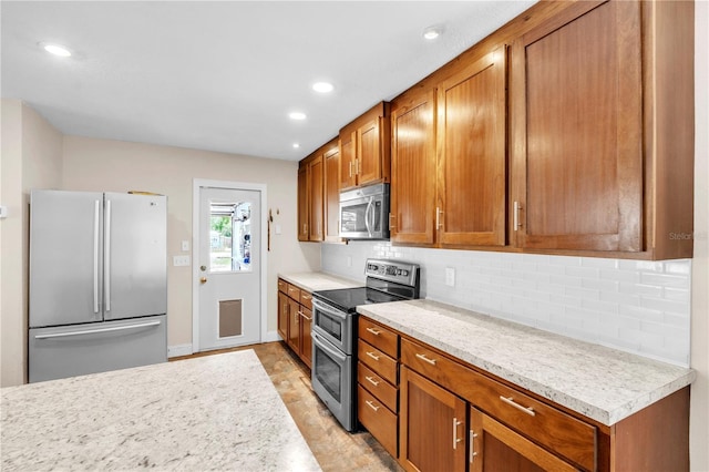 2218 Woodmere Rd, Venice, FL 34293 - kitchen with appliances with stainless steel finishes, brown cabinets, light countertops, tasteful backsplash, and recessed lighting