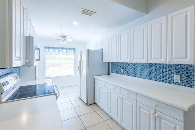 7137 Cedar Hollow Cir, Bradenton, FL 34203 - kitchen with white appliances, white cabinetry, tasteful backsplash, a ceiling fan, and light tile patterned flooring