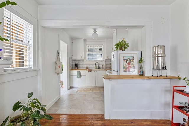 723 7th Ave N, Saint Petersburg, FL 33701 - kitchen with wood counters, white cabinetry, tasteful backsplash, ornamental molding, and light wood finished floors