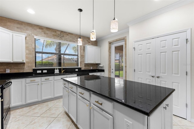 19023 Mangieri St, Venice, FL 34293 - kitchen featuring crown molding, light tile patterned floors, white cabinets, a center island, and black stove