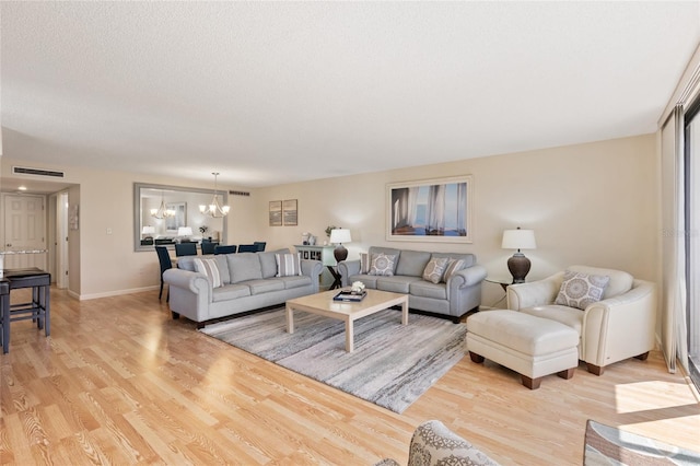 6265 Midnight Pass Rd Unit 205, Sarasota, FL 34242 - living room featuring a chandelier, light wood-style flooring, and a textured ceiling