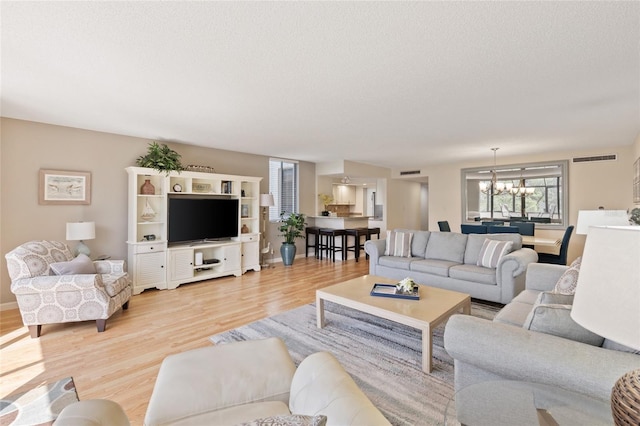 6265 Midnight Pass Rd Unit 205, Sarasota, FL 34242 - living area with light wood-type flooring, a chandelier, and a textured ceiling