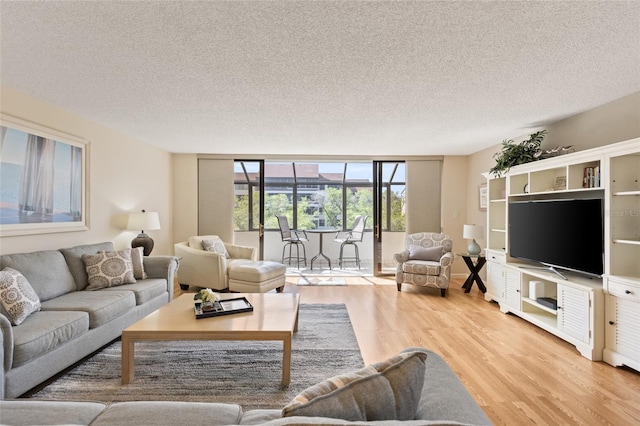 6265 Midnight Pass Rd Unit 205, Sarasota, FL 34242 - living area with floor to ceiling windows, light wood-style floors, and a textured ceiling