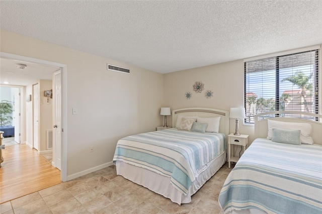 6265 Midnight Pass Rd Unit 205, Sarasota, FL 34242 - bedroom featuring multiple windows, a textured ceiling, and light tile patterned floors
