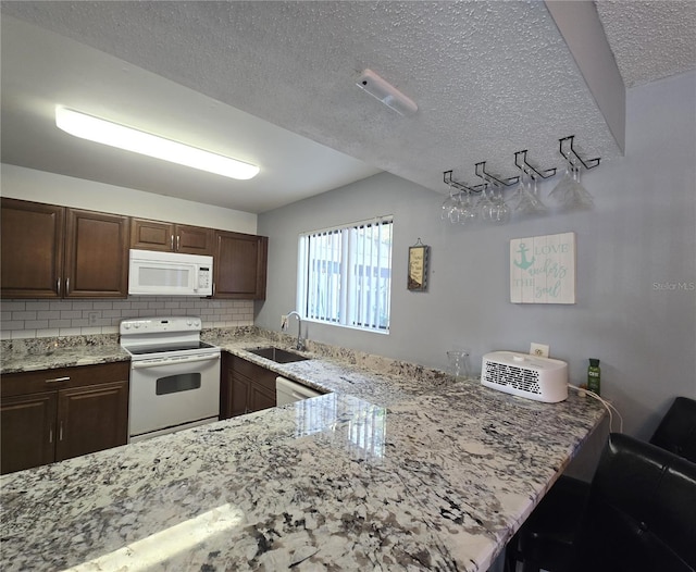4001 Beneva Rd Unit 319, Sarasota, FL 34233 - kitchen with white appliances, light stone counters, tasteful backsplash, a textured ceiling, and a peninsula