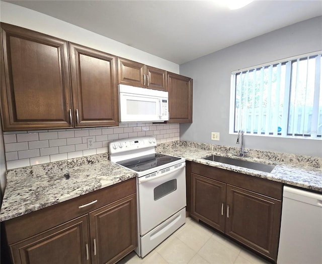 4001 Beneva Rd Unit 319, Sarasota, FL 34233 - kitchen with white appliances, backsplash, dark brown cabinets, and light stone counters