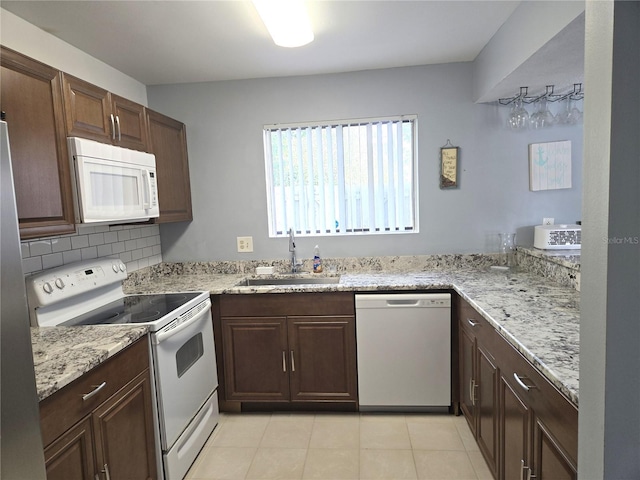 4001 Beneva Rd Unit 319, Sarasota, FL 34233 - kitchen featuring white appliances, light tile patterned floors, light stone countertops, and dark brown cabinetry