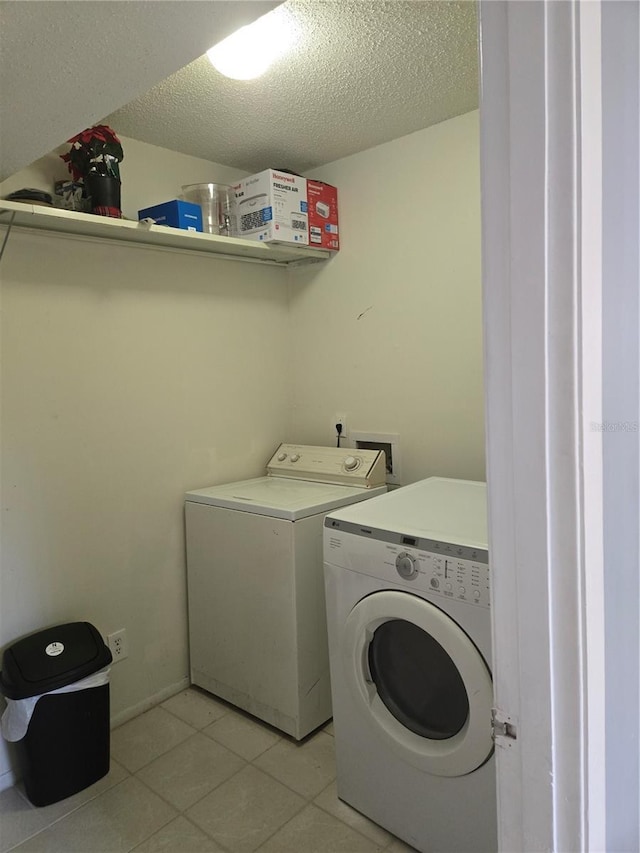 4001 Beneva Rd Unit 319, Sarasota, FL 34233 - washroom with washing machine and dryer, a textured ceiling, and light tile patterned flooring