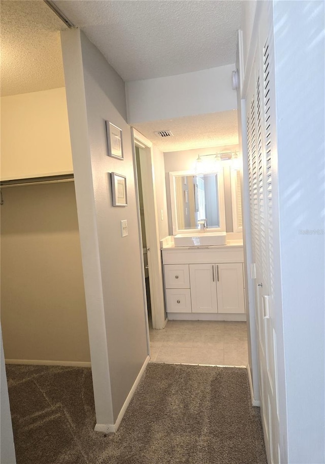 4001 Beneva Rd Unit 319, Sarasota, FL 34233 - corridor with light colored carpet, a textured ceiling, and light tile patterned floors