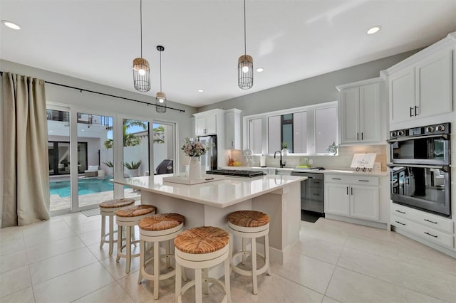 6317 Turtle Grass Dr, Bradenton, FL 34210 - kitchen featuring stainless steel appliances, backsplash, light countertops, a center island, and light tile patterned floors