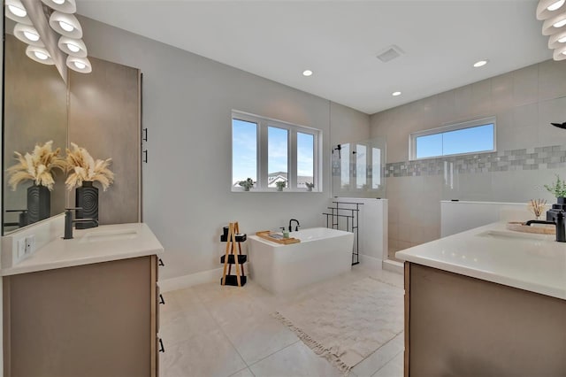6317 Turtle Grass Dr, Bradenton, FL 34210 - full bathroom featuring two vanities, walk in shower, a freestanding tub, tile patterned floors, and recessed lighting