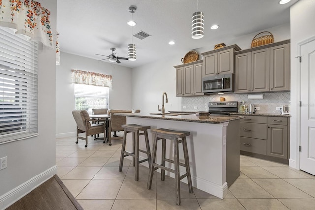 7750 Ridgelake Cir, Bradenton, FL 34203 - kitchen with stainless steel microwave, range with electric stovetop, gray cabinets, decorative backsplash, and recessed lighting